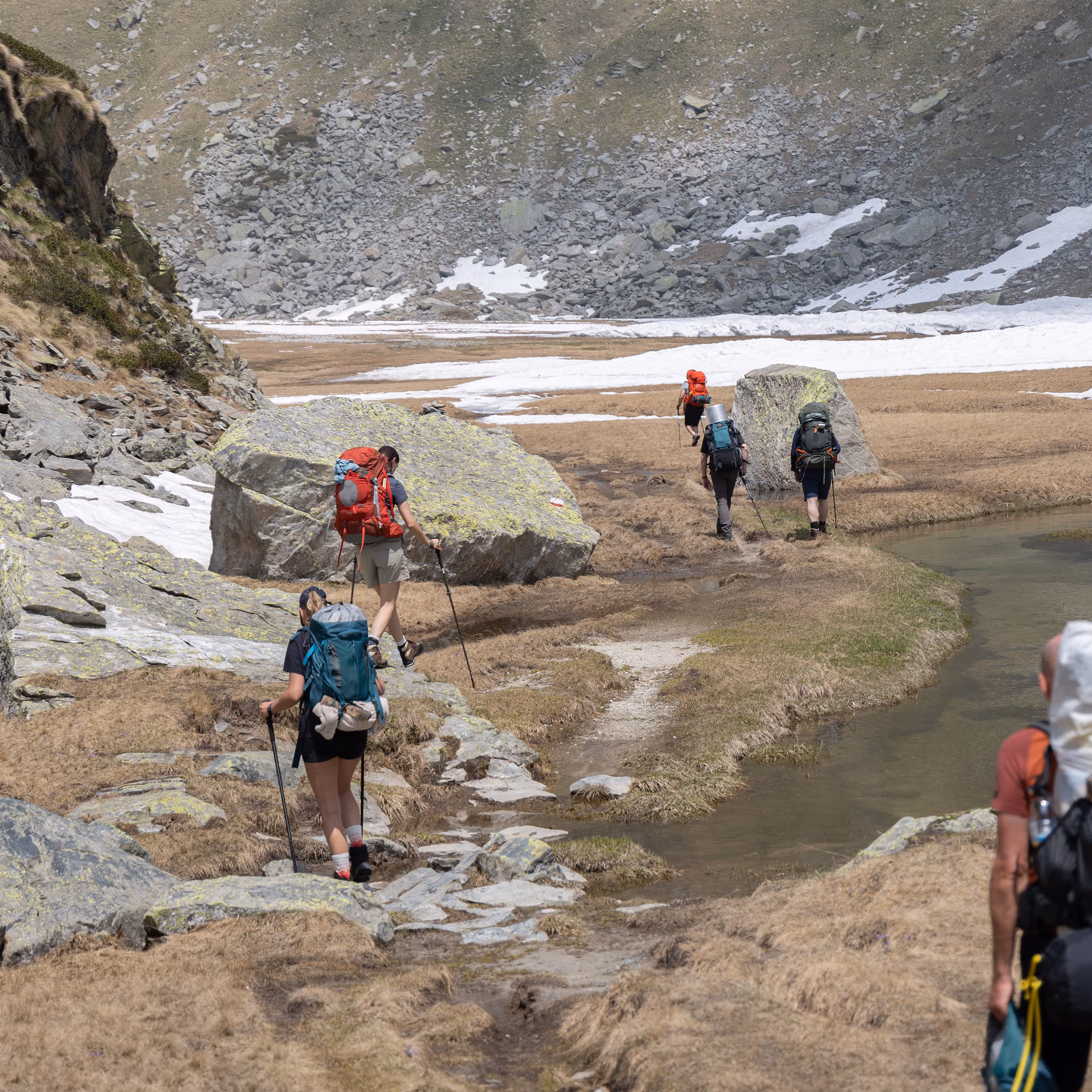 A walker on a rocky alpine trail with Monte Rosa behind