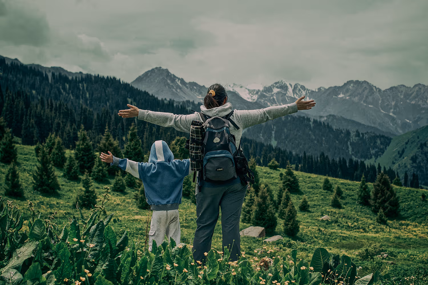 A parent and child walking a mountain trail together